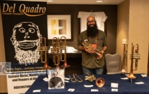 Mike Del Quadro, owner of Del Quadro Custom Trumpets, and his display of instruments at 2018 ITG
